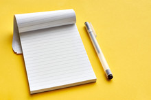 Top View Of Blank Open Notebook Page With Lines And Transparent Minimalistic Fineliner Pen On Yellow Background With Copy Space. For Use As Mock Up.    