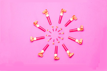 Party Blowers on pink background copy space