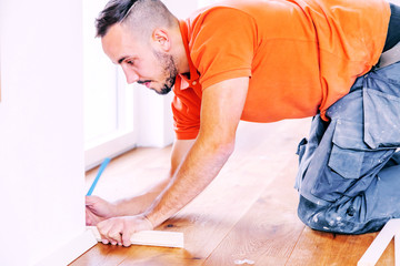 craftsman cuts wood plank with the chop saw on the construction