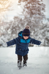 Wall Mural - Adorable, cute boy playing with snow cheerfully