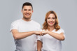© Syda Productions - relationships, friendship and people concept - portrait of happy couple in white t-shirts making fist bump gesture over grey background