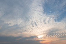 Natural Background. Evening Haze, Wavy White Clouds, Pink Glow Of Sunset. Beautiful Cloudscape