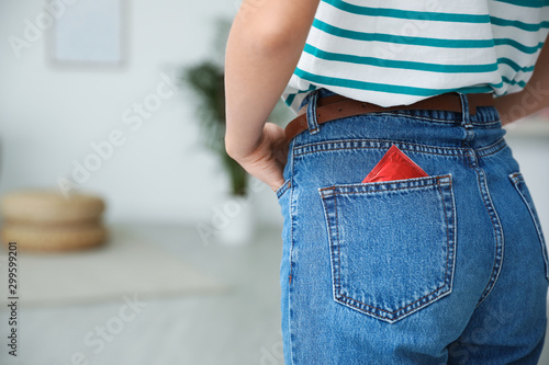 Fotomural Woman with condom in pocket of her jeans indoors, closeup
