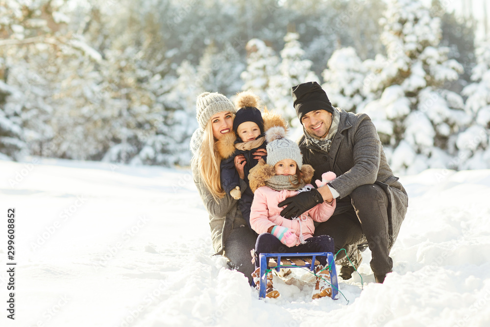 Family smiling in winter in a park - obrazy, fototapety, plakaty 