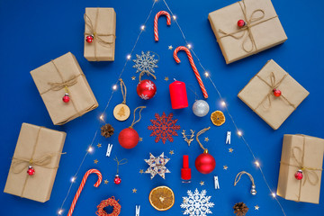 Christmas tree made of Christmas decoration on blue background. Holiday concept. Flat lay. Xmas