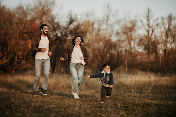 Happy family running together in park.