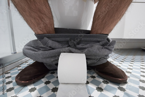Fotografía Pies de un hombre en el baño con papel higiénico