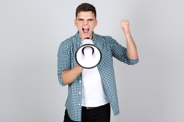 Sticker - Young man screaming in megaphone on grey background