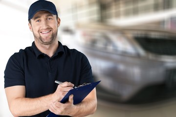 Wall Mural - Delivery man with clipboard on light background