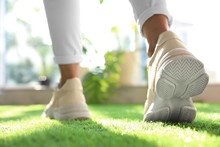 Young Woman Wearing Stylish Sneakers On Green Grass, Closeup