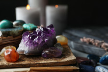 Many Different Gemstones And Blurred Candles On Background