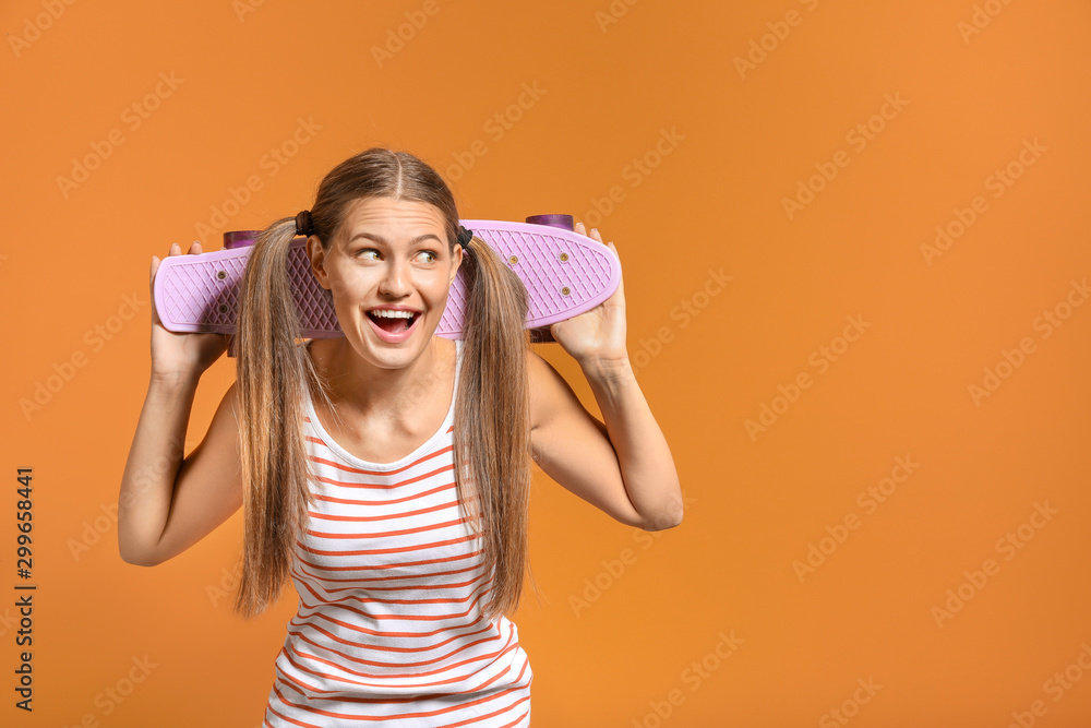 Happy young woman with skateboard on color background