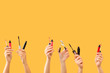 © Pixel-Shot - Many hands with decorative cosmetics on color background
