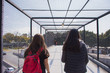 © ERNESTO - Two young women walk across a bridge on the street