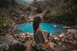 © zolotareva_elina - Beautiful young woman sitting at small mountain lake