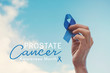Man Hands holding blue ribbon over blue sky, Prostate Cancer Awareness, November blue, Men health awareness