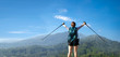 cheering woman hiker open arms at mountain peak.successful woman backpacker hiking on mountain peak