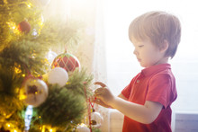 Happy Child Decorating The Christmas Tree With Balls. Christmas Eve Concept