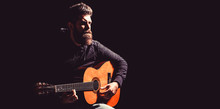 Bearded Man Playing Guitar, Holding An Acoustic Guitar In His Hands. Music Concept. Bearded Guitarist Plays. Play The Guitar. Beard Hipster Man. Copy Space