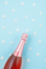 Wall Mural - Creative photo of champagne bottle with confetti on blue background