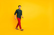 © deagreez - Full length photo of positive cheerful guy have free time go walk wear casual style outfit sneakers isolated over yellow color background