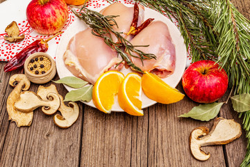 Wall Mural - Raw chicken boneless meat with herbs and fruits on plate. Cooking at Christmas time or Thanksgiving Day