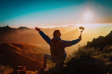 happy tourist making selfie in mountains, hiking in nature