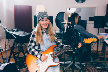 Wall Mural - girl playing guitar in music studio