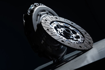 Close-up picture of a part of car, black clutch disk isolated on black background