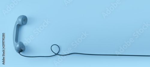 Fotografía A blue vintage dial telephone handset with blue background.