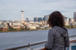 © edb3_16 - Downtown Seattle, Washington, United States of America. Girl on a Cruise Ship is enjoying the View of the Modern City on the Pacific Ocean Coast during a sunny and cloudy Autumn evening.