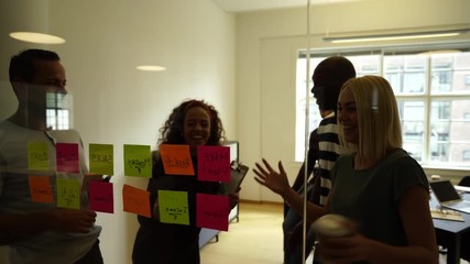 Wall Mural - Businesswoman laughing during an office meeting with coworkers