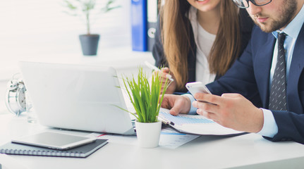 Image of two young businessmen working together on project at office