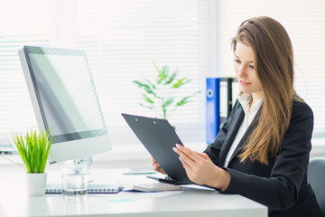 Image of young business woman working on project at office