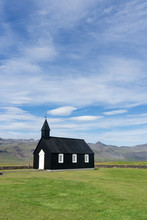 Black Icelandic Church On A Green Grass Lawn