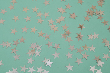 Wall Mural - Festive background. Colorful glitter stars on mint color background.