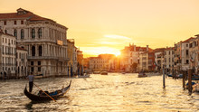 Venice At Sunset, Italy. Gondola With Tourists Sails On Grand Canal At Night. Panorama Of Venice City In Evening Sunlight. Scenery Of Sunny Street In The Venice Center. Nice Urban Landscape At Dusk.