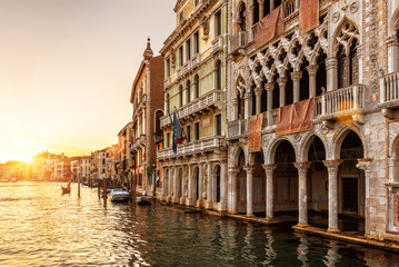 Wall Mural - Venice at sunset, Italy. Ca' d'Oro palace (Golden House) in foreground. It is landmark of Venice. Beautiful view of Grand Canal in the Venice center at dusk. Scenery of the old Venice city in evening.