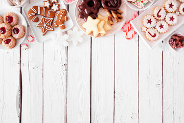 Wall Mural - Christmas cookie top border. Above view table scene over a white wood background with copy space. Holiday baking concept.