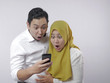 © airdone - Muslim Couple Shocked Surprised Looking at Smart Phone