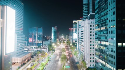 Wall Mural - Beautiful aerial hyperlapse of Seoul Gangnam District on the night. Camera moving between modern skyscrapers above the highway showing glittering lights of the streets, buildings and road traffic.