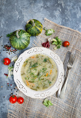 Wall Mural - A plate of vegetable soup on grey, stone background.