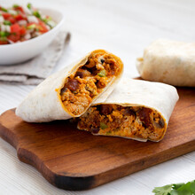 Homemade Chorizo Breakfast Burritos On A Rustic Wooden Board On A White Wooden Table, Side View. Close-up.