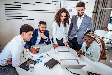 A group of young business people are communicating a project together in an office. Business concept.