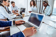 © HBS - Work in the office with colleagues. Meeting with business partners and work discussion. In the foreground in focus is a laptop.