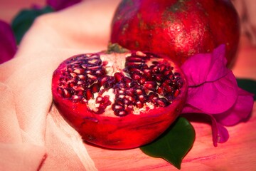 red pomegranate fruit and piece on pink background