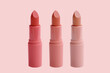 set of matte lipstick on a delicate pink background, red, raspberry, pink, coral, peach color, close-up, the concept of decorative cosmetics