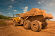 © Vladimir - large yellow dirty dump truck with large wheels loaded with earth