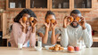 Funny black family having good time during breakfast at kitchen
