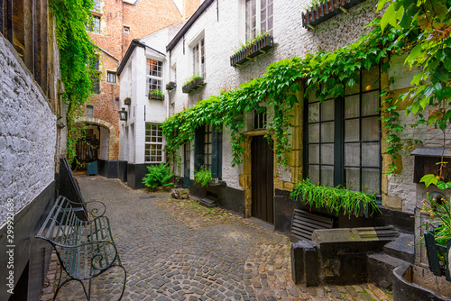 Old cozy narrow street with tables of restaurant in historic city center of A...